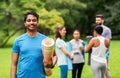 Smiling man with yoga mat over group of people Royalty Free Stock Photo