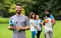 Smiling man with yoga mat over group of people Royalty Free Stock Photo