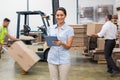 Smiling manager using digital tablet during busy period