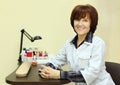 Smiling manicurist sits at table for manicure