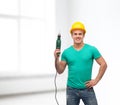 Smiling manual worker in helmet with drill machine Royalty Free Stock Photo