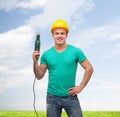 Smiling manual worker in helmet with drill machine Royalty Free Stock Photo