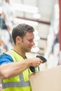 Smiling manual worker scanning package Royalty Free Stock Photo