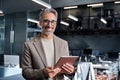 Smiling mature business man executive standing in office with tablet. Portrait Royalty Free Stock Photo