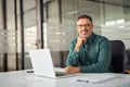 Smiling mature business man sitting at work desk in office, portrait. Royalty Free Stock Photo