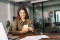 Smiling mature business woman executive using mobile phone working in office. Royalty Free Stock Photo