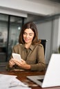 Happy mature business woman executive using mobile phone working in office. Royalty Free Stock Photo