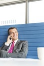 Smiling mature businessman talking on cell phone in office Royalty Free Stock Photo