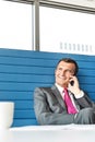 Smiling mature businessman talking on cell phone in office Royalty Free Stock Photo