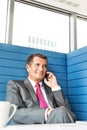 Smiling mature businessman talking on cell phone in office Royalty Free Stock Photo