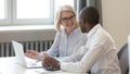 Smiling mature businesswoman coach training African American employee