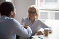 Smiling mature businesswoman shaking hand of African American colleague Royalty Free Stock Photo