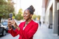 Smiling mature businesswoman using mobile phone in urban setting Royalty Free Stock Photo