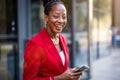 Smiling mature businesswoman using mobile phone in urban setting Royalty Free Stock Photo