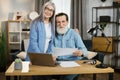 Smiling mature caucasian people man and woman using modern laptop for work at office Royalty Free Stock Photo