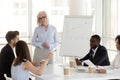 Smiling mature coach communicating with team at business meeting Royalty Free Stock Photo