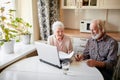 Smiling mature couple with documents and laptop in home interior Royalty Free Stock Photo