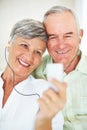 Smiling mature couple listening music together. Closeup of smiling mature couple listening music together at home. Royalty Free Stock Photo