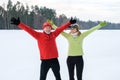 Smiling mature couple with outstretched arms in park in winter Royalty Free Stock Photo