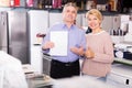 Smiling mature couple took credit for home appliances