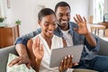 Happy smiling african couple doing video call with digital tablet at home Royalty Free Stock Photo