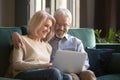 Smiling mature couple, wife and husband using laptop together at home Royalty Free Stock Photo