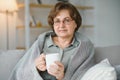 Smiling mature elder 65s woman sitting relaxing with cup of tea, coffee. Senior mid age stylish look woman with Royalty Free Stock Photo