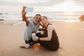 Smiling mature european woman and man in sportswear rest from training together, drink bottle of water, take selfie Royalty Free Stock Photo