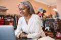 Smiling mature woman working online in her fabric store Royalty Free Stock Photo