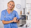 Female doctor writing notes on clipboard in clinic Royalty Free Stock Photo