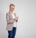 Smiling mature female entrepreneur checking messages over mobile phone on isolated white background Royalty Free Stock Photo