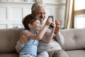 Smiling mature grandfather and little grandson use cellphone Royalty Free Stock Photo