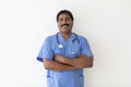 Smiling Mature Indian Male Doctor In Uniform Posing Over White Background Royalty Free Stock Photo