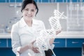 Smiling mature lady examining three dimensional dna model in lab Royalty Free Stock Photo