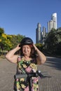 Smiling mature latin woman putting on a helmet to ride her electric kick scooter Royalty Free Stock Photo