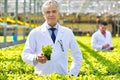 Smiling mature male botanist in plant nursery