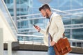 Smiling mature man with bag using cell phone Royalty Free Stock Photo