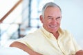 Smiling mature man at home. Portrait of handsome mature man smiling while sitting at home. Royalty Free Stock Photo