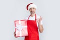 smiling mature man in santa hat and red apron hold present Royalty Free Stock Photo