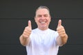 Smiling mature man showing his new teeth and giving a double thumbs up Royalty Free Stock Photo