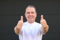 Smiling mature man showing his new teeth and giving a double thumbs up Royalty Free Stock Photo