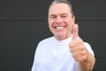 Smiling mature man showing his new teeth and giving a thumbs up gesture Royalty Free Stock Photo