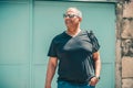 Senior lifestyle travel. Portrait of mature man with sunglasses and backpack, traveling on city vacation. Royalty Free Stock Photo