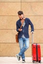 Smiling mature man with suitcase and mobile phone Royalty Free Stock Photo