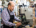 Mature man making duplicates of keys . Royalty Free Stock Photo