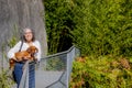 Smiling mature Mexican woman with glasses hugging her dachshund next to a metal fence