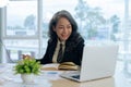 Smiling mature middle aged business woman using laptop working and sitting at desk Royalty Free Stock Photo