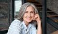 Smiling mature middle aged woman sitting at workplace, portrait. Royalty Free Stock Photo