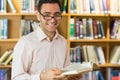 Smiling mature student reading book in library Royalty Free Stock Photo