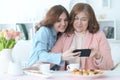 Smiling mature woman with adult daughter looking at smartphone Royalty Free Stock Photo